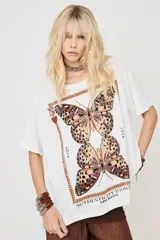 Remera blanca de manga corta con calce holgado, con estampa frontal de mariposas y texto "Authenticity is power".