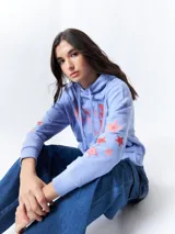 Canguro lila de manga larga y capucha, con estampa de rayos y estrellas en color coral en el frente y las mangas.