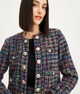 Blazer corto confeccionado en tweed multicolor con forro, escote U, manga larga y botones escudo dorados.