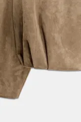 Chaqueta de efecto ante con cuello solapa envolvente, manga larga con hombro caído y bajo con elástico interior. Cuenta con bolsillos laterales ocultos en costura y forro interior.