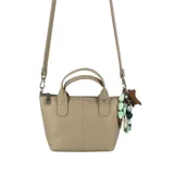 Cartera mini tote de cuero marrón, con diseño compacto y líneas modernas. Cuenta con doble asa de mano, correa larga regulable y extraíble, cierre superior y un dije decorativo con cuentas de colores.