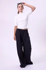 Pantalón palazzo negro de tiro alto con pinzas y bolsillos laterales.