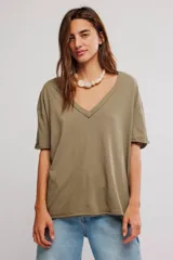 Remera oversize de algodón en color verde militar, con escote en V amplio, mangas cortas caídas y detalles de costuras visibles en los bordes.