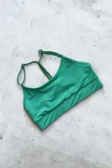 Top deportivo verde esmeralda con breteles regulables y espalda deportiva. Incluye almohadillas removibles.