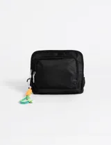 Bolso bandolera pequeño color beige, confeccionado en poliéster con cierre frontal y compartimento principal. Incluye un llavero decorativo de cuerda multicolor con mosquetón.