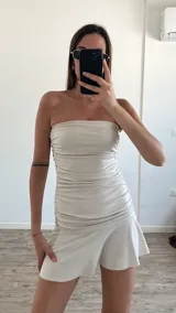 Vestido corto color amarillo pastel, strapless, con frunces laterales y falda con volados.