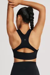 Top deportivo negro de cintura ancha, realizado en tela doble suave y de alta elasticidad. Detalle de breteles cruzados en la espalda.