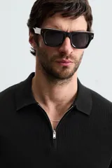 Polo de manga corta, color azul medio, tejido en punto perlado con cuello solapa y cierre frontal de cremallera.