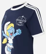 Remera azul marino de algodón con cuello redondo y mangas cortas con rayas blancas en los hombros. Estampado frontal de la Pitufina jugando al tenis.