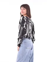 Blusa de mangas largas con estampado de hojas en tonos celeste y azul marino, con lazo en la cintura.
