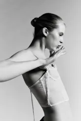 Corsé strapless color beige claro, con copas con aros y estructura de varillas verticales. El tejido es semitransparente con pequeños lunares visibles. Presenta un cierre frontal con ganchos.