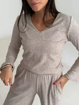 Remera de lanilla con textura acanalada, escote en V y mangas largas estilo oxford. Presenta un diseño ajustado al cuerpo.