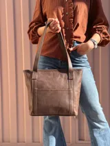 Cartera shopper de cuero color marrón chocolate, con doble asa de hombro, bolsillo frontal externo y diseño estructurado.