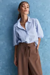 Pantalón wide leg de color negro, con cintura de tiro alto, lazo ajustable y caída fluida.