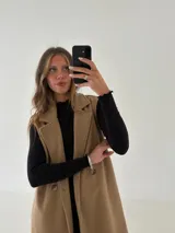 Remera de morley color mostaza, de manga larga, con cuello alto fruncido y terminaciones fruncidas en las mangas.