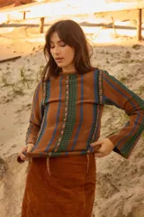 Sweater de lana de cordero con cuello a la base y manga larga. Presenta un diseño de franjas verticales combinando tejido de punto con detalles en crochet y cintas de lúrex brillante.