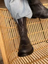 Bota tipo borceguí de cuero color azul noche, con diseño de estilo brogue en la puntera. Presenta elástico lateral, cierre interno y suela de goma con taco bajo.