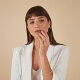 Esclava rígida de oro 18k con acabado satinado y diseño de cinta plana. Presenta una textura fina en su superficie y un diseño minimalista.