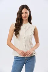 Musculosa de lino rayada con cuello mao y volados en los hombros. Presenta diseño de rayas verticales y aplique de etiqueta con logo en la parte posterior.