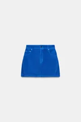 Falda mini de pana azul, con diseño de cinco bolsillos, cierre frontal con cremallera y botón.
