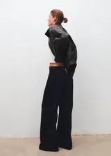Pantalón de tiro alto confeccionado en tejido de pana con diseño wide leg. Cuenta con cierre de botón y cremallera, trabillas para cinturón y cinco bolsillos clásicos.