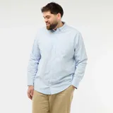 Camisa de corte recto confeccionada en tejido oxford de algodón, color celeste claro. Presenta cuello abotonado, cierre frontal con botones y mangas largas con puños abotonados.