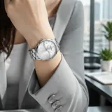 Reloj analógico de mujer con caja y malla de acero inoxidable plateado. Presenta una esfera con diseño texturizado en espiral, detalles de cristales y cierre desplegable con botón de seguridad.