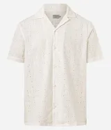 Camisa de manga corta color blanco con cuello inglés y cierre frontal de botones, confeccionada en algodón con textura perforada tipo broderie.