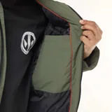 Parka color verde militar con capucha, cierre frontal de cremallera, bolsillos de parche con doble entrada y forro interior.