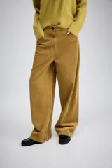 Pantalón de tiro medio confeccionado en tejido de pana, con diseño de pierna ancha, bolsillos delanteros y traseros, y cierre frontal con cremallera y botón.