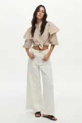 Jean blanco wide leg de tiro alto, con costuras decorativas verticales al frente y pernera ancha.
