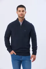 Buzo de punto texturado azul marino con cuello alto y cierre frontal parcial. Cuenta con detalles de rib en puños y cintura, y sutil logo bordado en el pecho.
