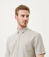 Camisa de hombre de manga corta confeccionada en mezcla de lino y algodón. Presenta un calce comfort, cuello camisero, cierre frontal con botones y un bolsillo en el pecho. Marca Marfinno.