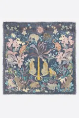 Chal azul marino de forma cuadrada con un diseño estampado de leopardos, palmeras, flores y estrellas. Cuenta con bordes deshilachados.