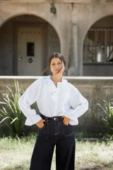 Camisa de lino blanca con volados en el cuello y en los puños, de corte holgado y mangas largas abullonadas.