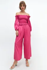 Crop top blanco con escote off-shoulder, punto panal en el torso y volados en el escote.