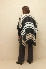 Poncho con diseño a rayas en tonos negro, blanco y beige.