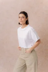 Remera crop color beige, de calce amplio, escote redondo y mangas cortas sueltas.
