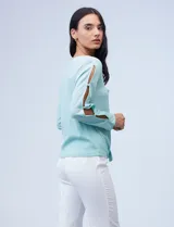 Blusa tejida color celeste con lurex, de manga larga con aberturas y apliques de brillo. Ruedo anudado.