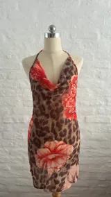 Vestido corto de microtul con estampado animal print y flores rojas, escote drapeado y tirantes finos.