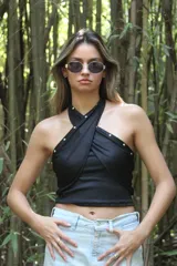 Top negro con diseño cruzado en el frente, estilo halter y con detalles de tachas doradas.