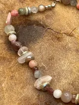 Collar corto con cuentas de piedras naturales en tonos rosados, beige y plateado.