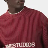 Sweater de punto grueso color bordó de EME Studios, con cuello redondo, puños y bajo de canalé, y logotipo bordado en el pecho. Presenta una silueta holgada y cuadrada.