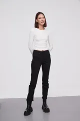 Pantalon jean de corte skinny y tiro alto, con diseño clásico de cinco bolsillos y cierre frontal con botón y cremallera.