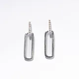 Aros colgantes plateados con forma rectangular y detalle de strass en la parte superior.