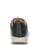 Championes Hush Puppies modelo Spinal Laceup de cuero color negro, con cordones grises, ojalillos metálicos dorados, entresuela gris y suela de goma.