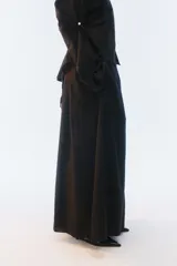 Pantalón amplio de largo maxi, color negro, con piernas anchas, cintura elástica fruncida y diseño de tela liviana con textura calada transparente.