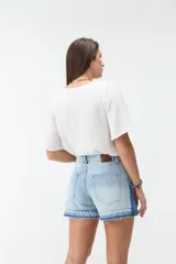 Short de denim blanco de tiro medio, con costuras pespuntadas en contraste y terminación desmechada en el ruedo.