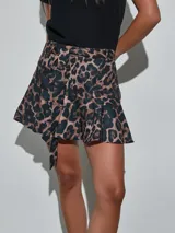 Minifalda con estampado animal print de leopardo, tiro alto, con cinturón ajustable del mismo género y detalle de volado en el ruedo.