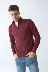 Campera negra de algodón con cierre completo, cuello alto, bolsillos laterales, puños y logo bordado en el pecho.